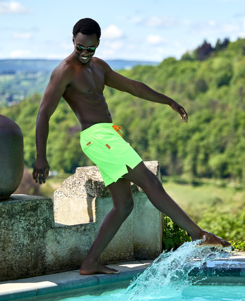 Man wearing neon green swim shorts