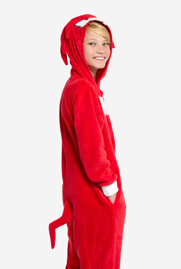 A kid is wearing a bright red Knuckles the Echidna-themed kids onesie from OppoSuits. The fun and cozy onesie features a zip-up front and an attached hood designed to resemble Knuckles' face, complete with expressive eyes and floppy dreadlocks. The suit is primarily red, with a white crescent pattern on the chest, reflecting Knuckles' iconic look from the Sonic the Hedgehog video game series. 