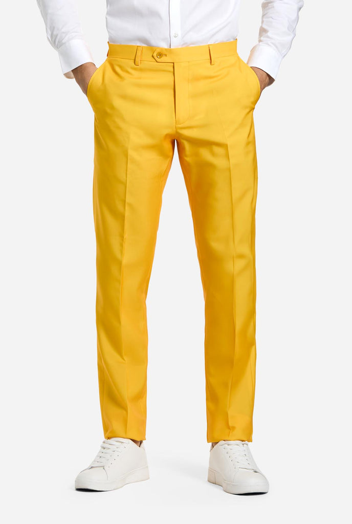 Man wearing men's Christmas suit with the character ELF on the jacket and yellow pants, pants view