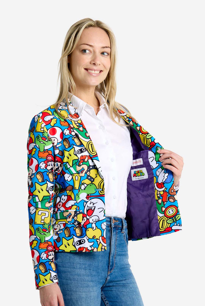 Woman wearing all-over print Super Mario blazer with iconic Super Mario characters. The base is light blue, but there is also yellow, red and white.