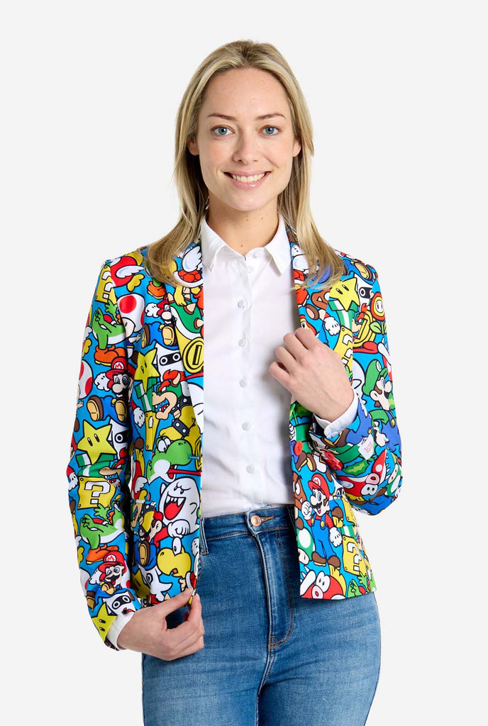 Woman wearing all-over print Super Mario blazer with iconic Super Mario characters. The base is light blue, but there is also yellow, red and white.