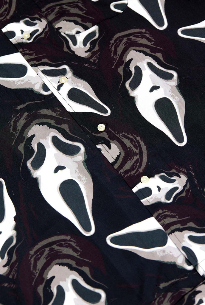 Man wearing black Hawaiian shirt with Ghostface print, close up