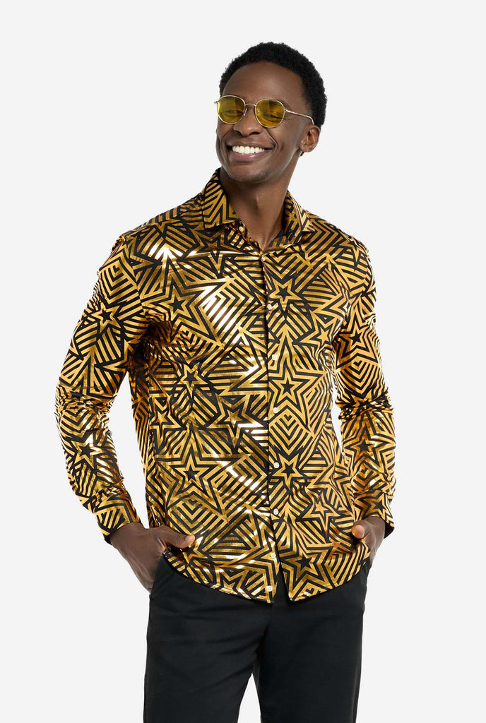 This image features a men’s shirt from OppoSuits with a vibrant gold and black geometric star print pattern. The shirt has a reflective finish that highlights the intricate star and line designs, creating a dynamic and stylish look. Perfect for those who want to stand out, this shirt is both bold and fashionable, ideal for parties, holiday celebrations, or nightlife. The model wears it paired with black pants, and yellow glasses.