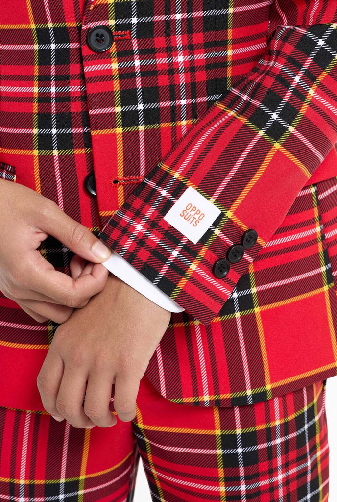 Teen wearing red tartan Christmas suit, close up sleeve