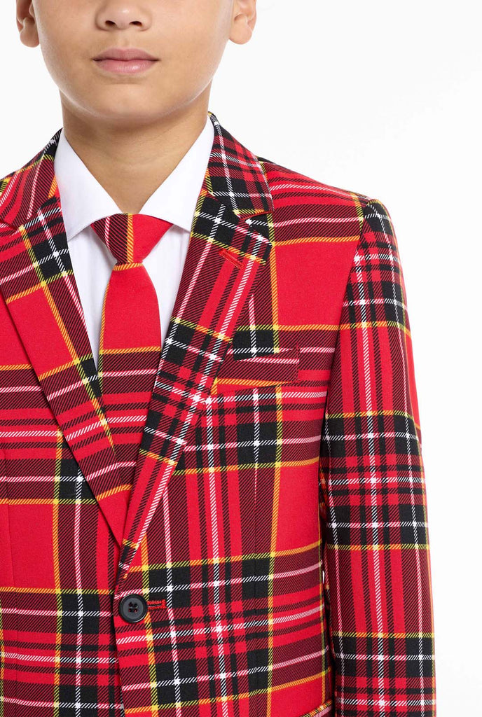 Teen wearing red tartan Christmas suit, chest close up.