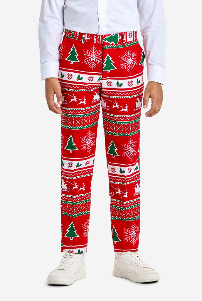 Teen wearing red Christmas suit with green and white Christmas icons, like Christmas tree, snowflakes, holly and sled with reindeers.