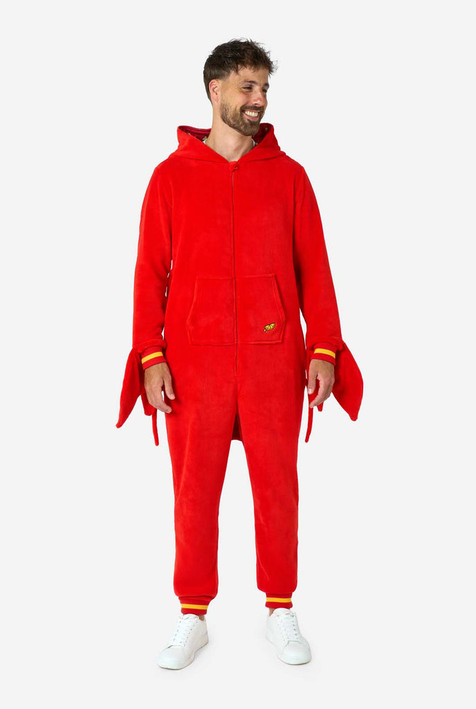 A man is wearing a bright red lobster-themed adult onesie featuring playful hood details and cozy, soft material, perfect for lounging or costume events. including stitched gloves as claws. Full body image and hood down on his back.