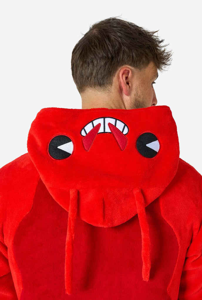 A man is wearing a bright red lobster-themed adult onesie featuring playful hood details and cozy, soft material, perfect for lounging or costume events. including stitched gloves as claws. Close up from the hood dow on his back.