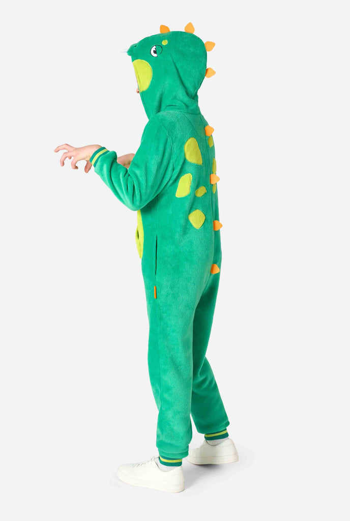 Kid is wearing green dino onesie for kids. Side view.