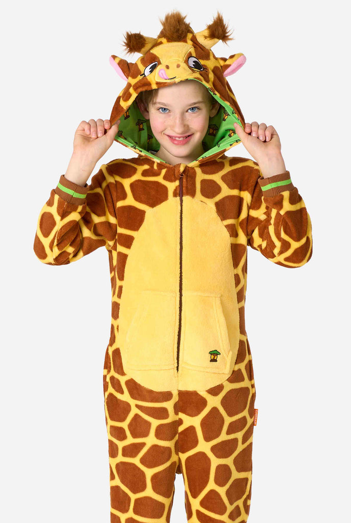 A smiling kid is wearing a brown and yellow kids onesie designed as a giraffe. The onesie features a hood resembling a Giraffes head.